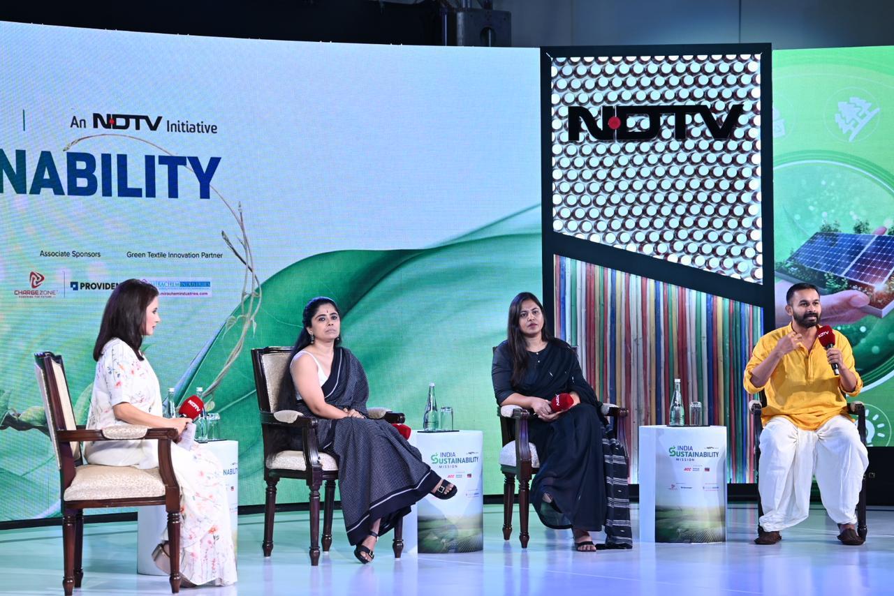 Four-person panel discussion in progress on the NDTV India Sustainability Mission set
