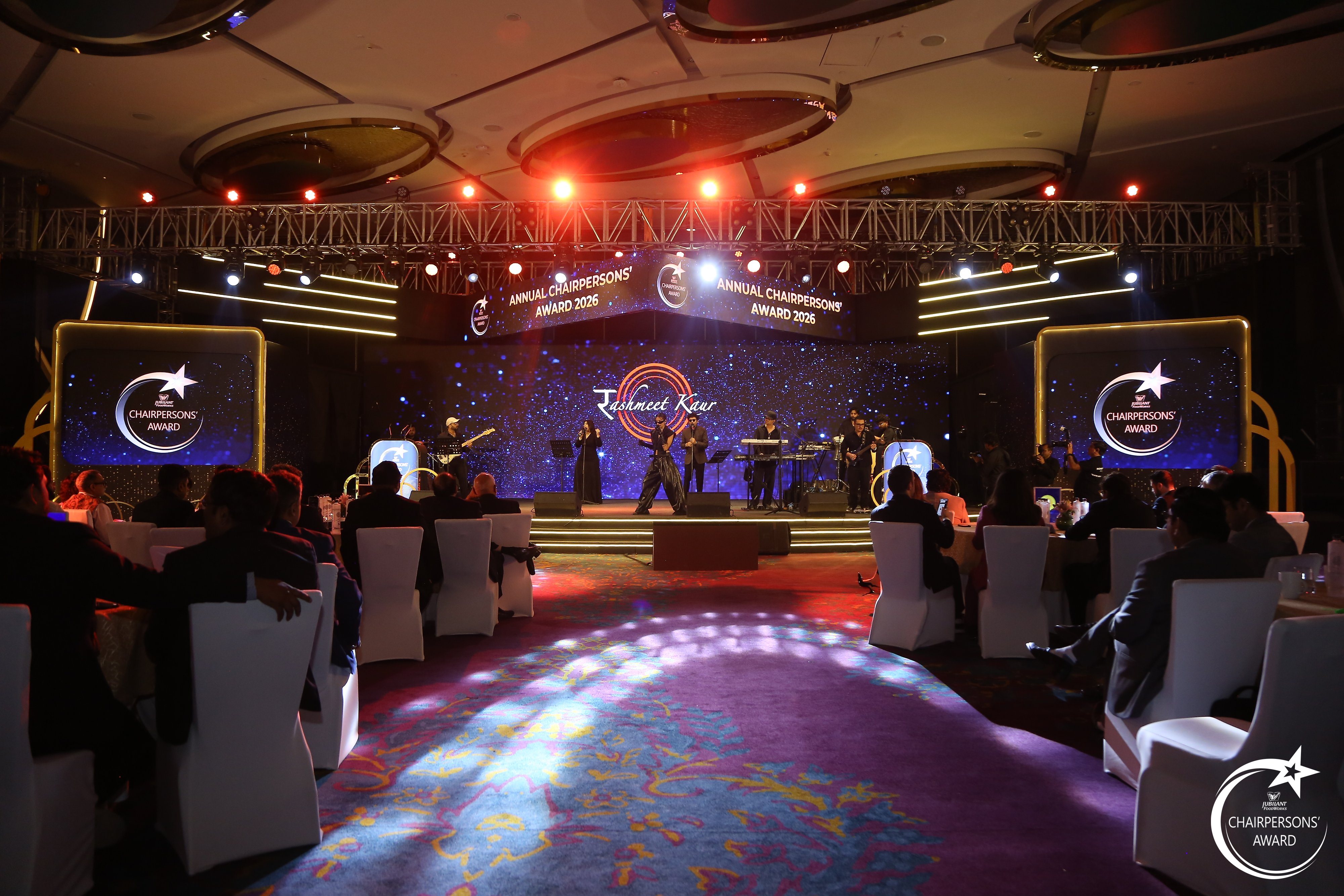 Rashmeet Kaur performing live with the band on the Annual Chairpersons’ Award stage, with guests seated at banquet tables