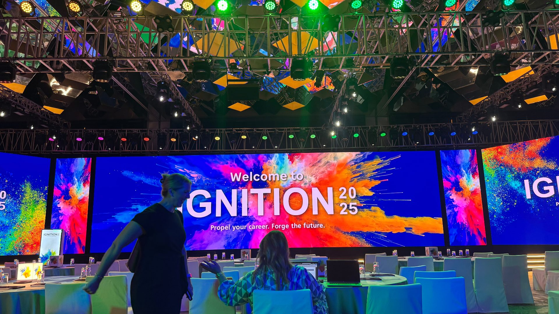 Delegates taking their seats at the cabaret rounds as the Ignition 2025 key art fills the curved LED wall