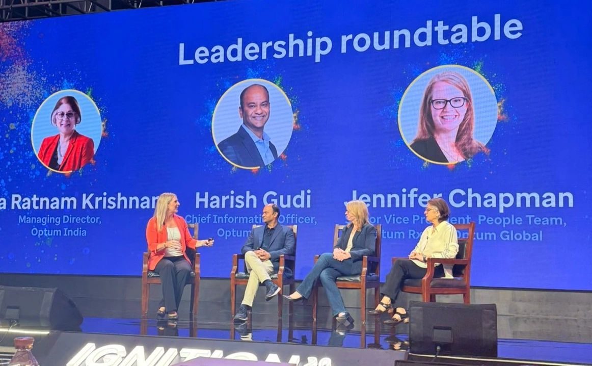 Optum leadership roundtable in session, with speaker portraits displayed across the LED backdrop