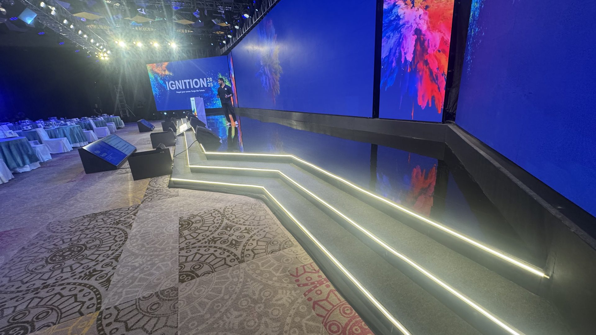 Light-lined stage steps running the length of the set, with the Ignition key art carried across the LED wall behind