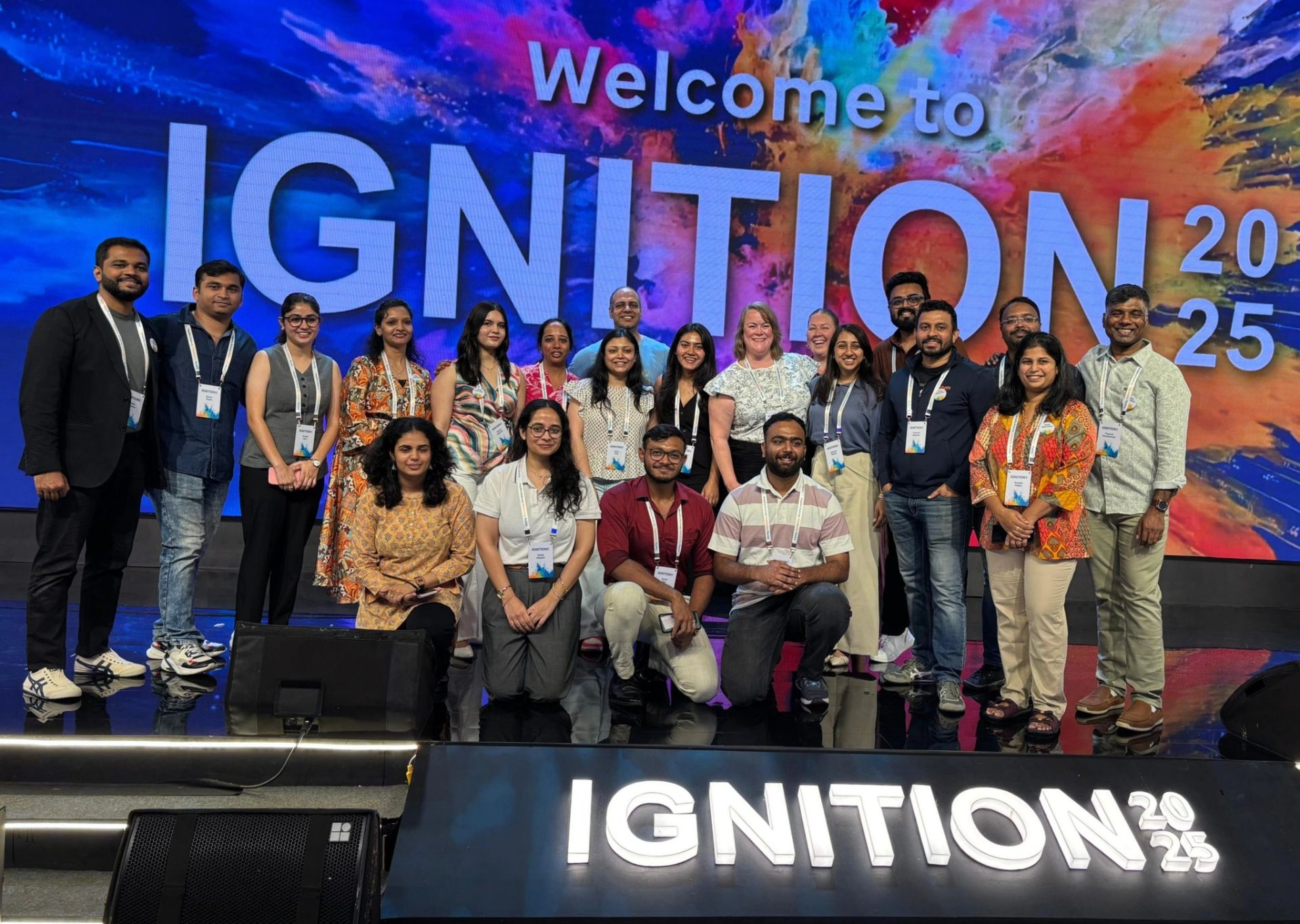 Optum team photographed on stage in front of the Welcome to Ignition 2025 LED wall at Grand Hyatt Gurgaon